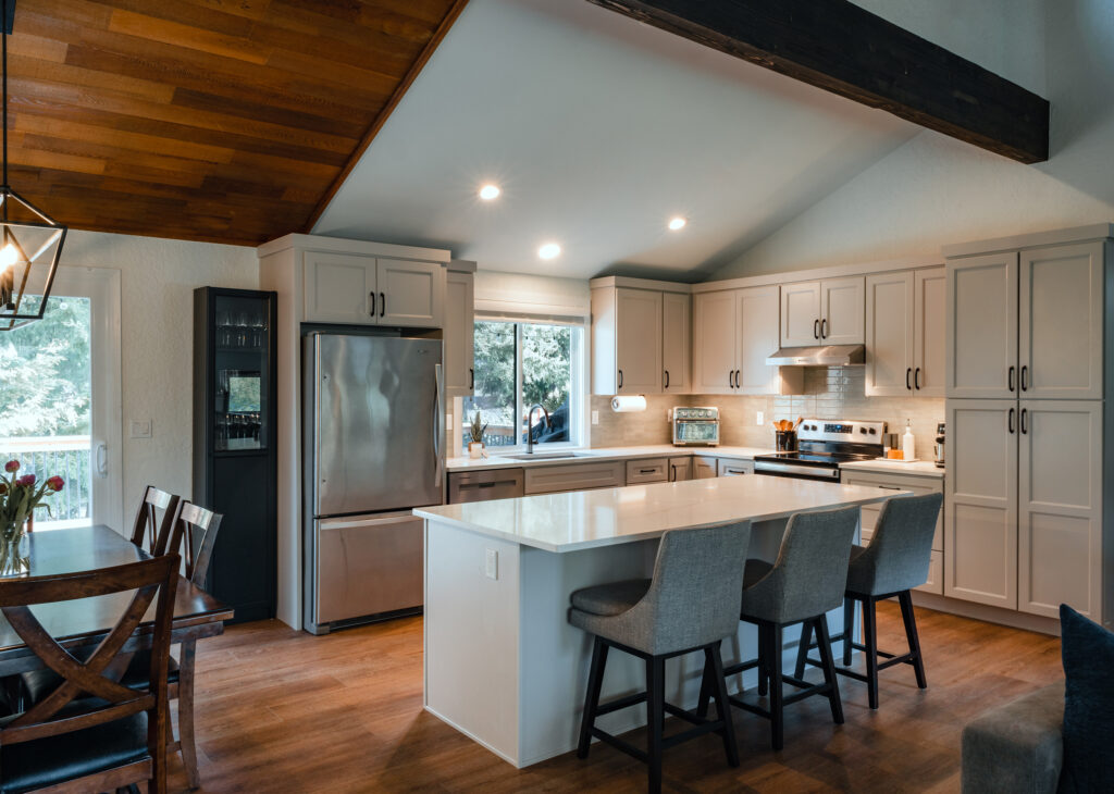 Edmonds Kitchen with large island in the middle, grey cabinets and a window over the sink.